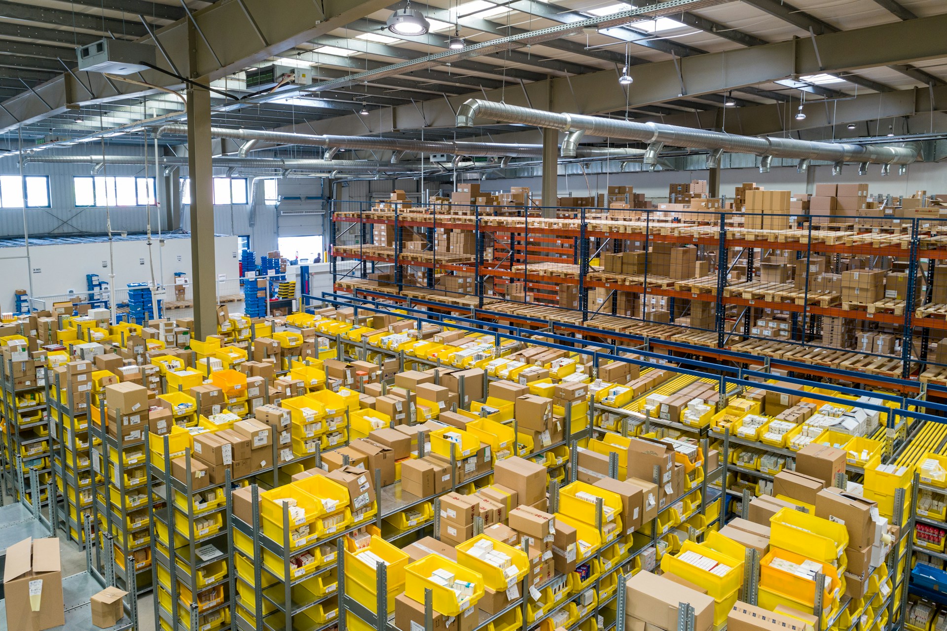 An industrial fulfilment centre with stocked shelves and sorting stations